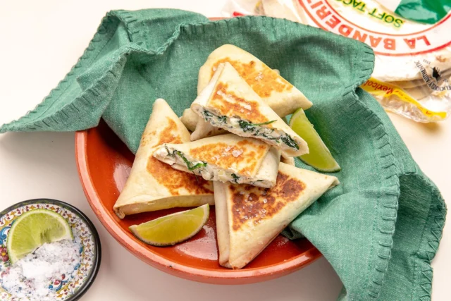 THIS is what to make when you’re asked to bring a plate! Crispy, creamy and delicious, these fetta & spinach tortilla triangles are guaranteed to please a crowd 💚
YOU’LL NEED
• 3 La Banderita Burrito Grande tortillas
• 1 onion, finely chopped
• 3 large handfuls baby spinach
• 500g ricotta
• 150g fetta, crumbled
• handful of grated parmesan
•1/2 tsp dried oregano
• 2 sprigs of dill 
• 1 egg
• Olive oil, salt & pepper
HOW TO
👉 Sauté onion in olive oil, then add spinach, oregano and salt. Cook for 1–2 mins until wilted. Cool slightly.
👉 Mix ricotta, fetta, parmesan, egg and dill. Fold through the spinach mixture.
👉 Cut tortillas in half, add a spoonful of filling and fold into triangles, tucking in the final edge to seal.
👉 Spray with oil and pan-fry over medium-high heat for 2–3 mins each side, until golden and crisp. Serve warm and watch them disappear.
Save this one for your next night with friends!
#LaBanderita #TortillaRecipes #EasyRecipes #SpinachRecipes #Entertaining